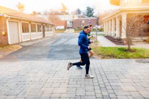 Trinity college student athletes running through campus